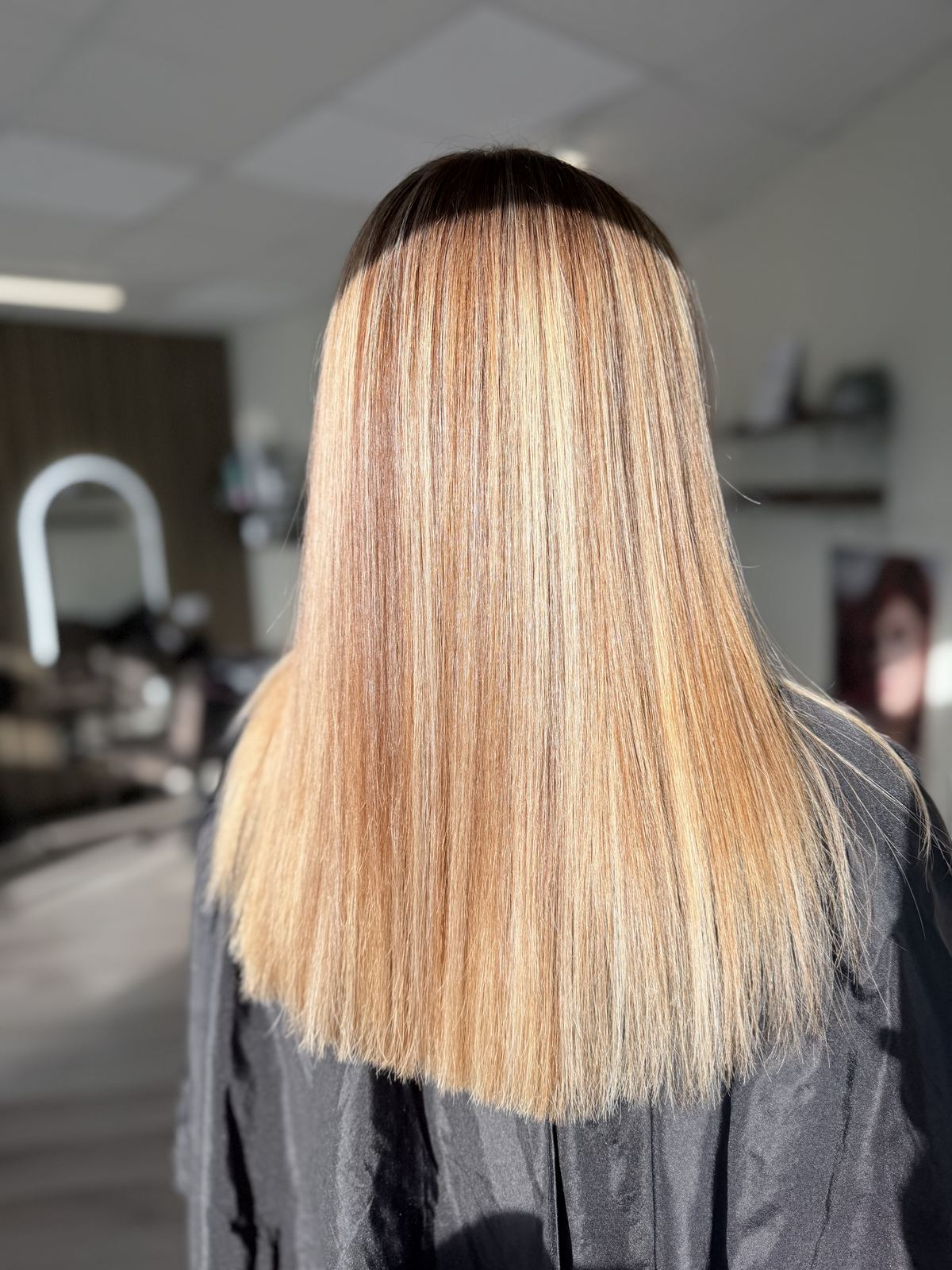 Straight blonde hair with darker root shadow